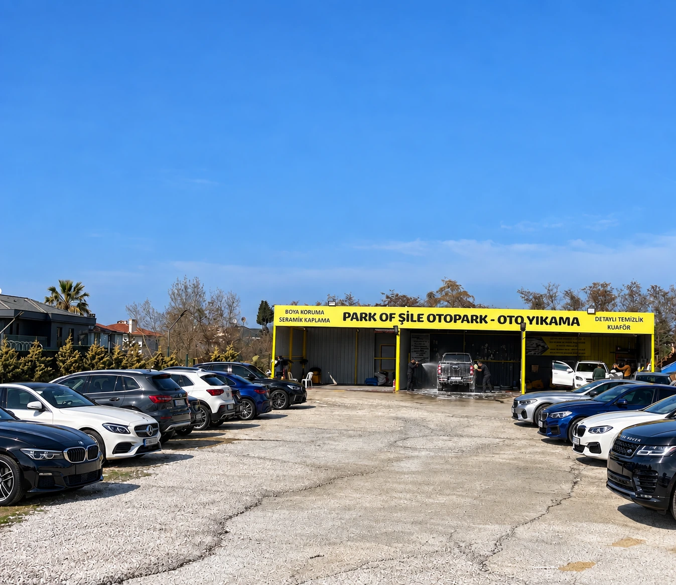 Park Of Şile oto yıkama ve otopark alanı; orta bölümde aracı yıkayan çalışanlar ve iki yanda park edilmiş otomobiller
